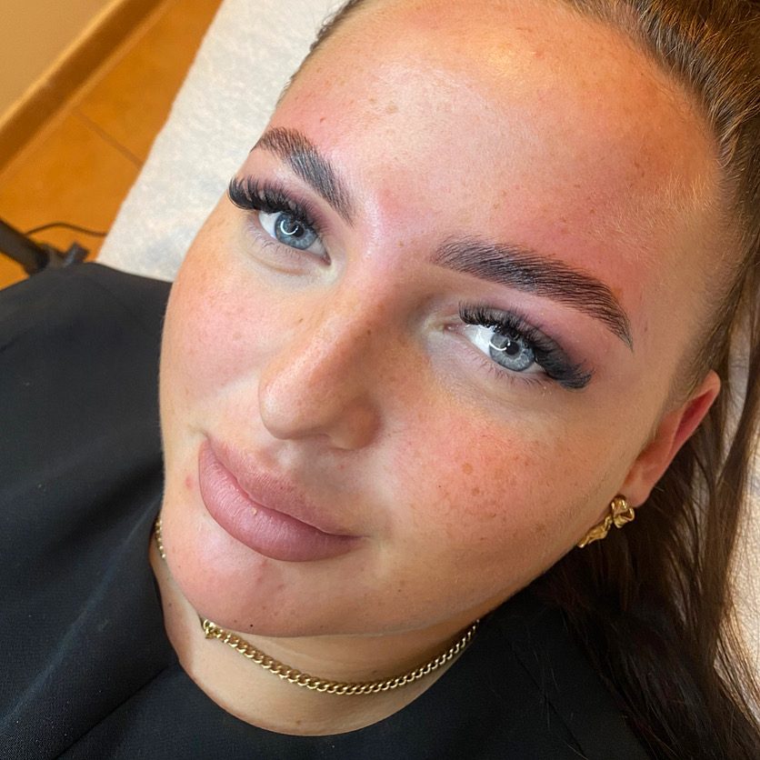 Defined brows and lifted lashes on a client in a black top