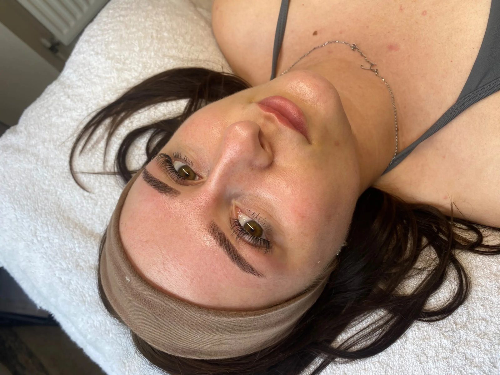 Laminated brows on a client lying back with a headband