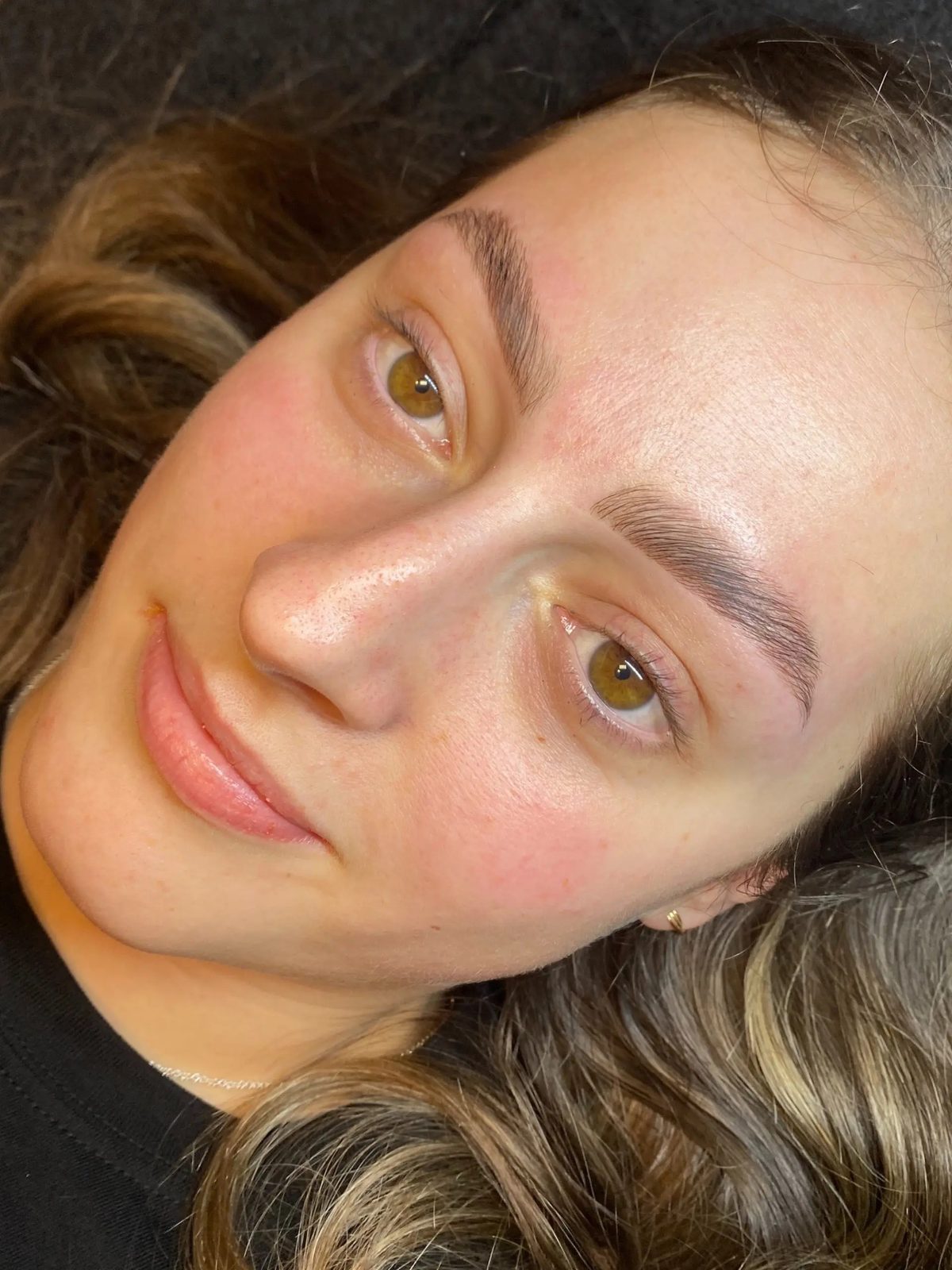 Soft, fluffy laminated brows on a client with hazel eyes