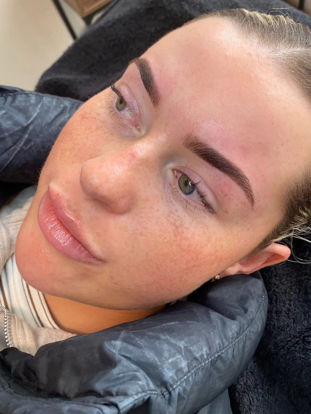 Natural brows on a client in a black puffer jacket